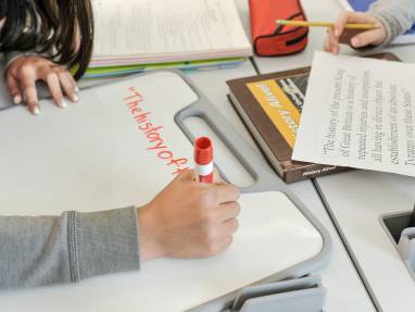student writing on personal whiteboard