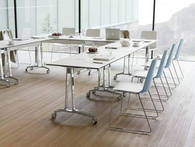 A group of chairs designed by Wiesner-Hager arranged around tables with casters in a conference room