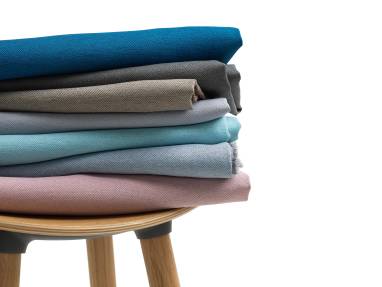variety of upholstery stacked on stool