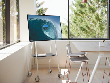 A screen is displayed on a Steelcase Roam mobile stand next to a Potrero415 table and Montara seating