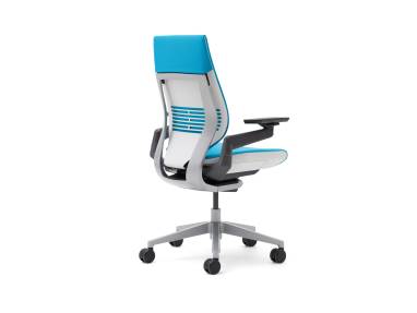 A blue, wrapped-back gesture chair from the back with the seat facing the right