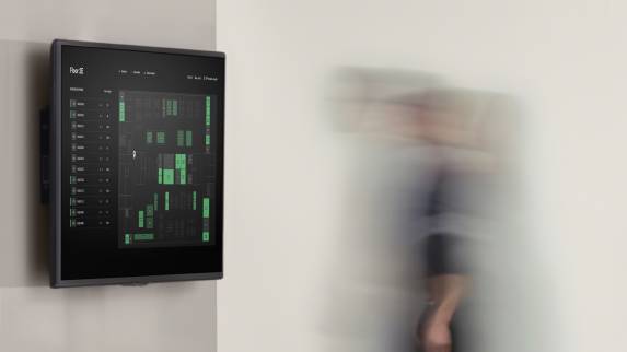 Steelcase Live Map attached to a wall while a person walks by in the background