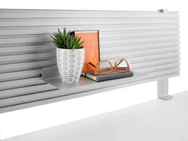 A notebook, glasses and other personal items sit on a small shelf affixed to the slatwall