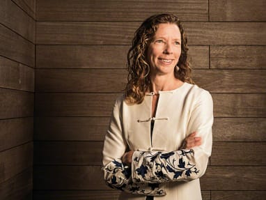 Donna Flynn standing over a wood wall