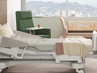 patience room with a green Empath chair, a large sofa and a medical bed.