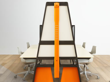 An orange Turnstone Bivi Bike Hook mounted on an orange Turnstone Bivi Team Table surrounded by gray Steelcase Shortcut 5-Star Chairs.