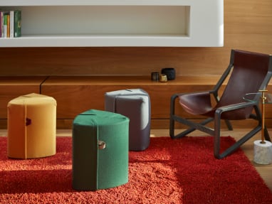 Ancillary space equipped with Turnstone Campfire Poufs in a variety of colors and a burgundy BluDot Toro Lounge Chair