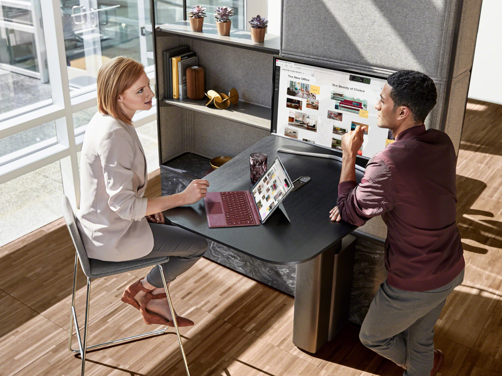 A Mackinac desk with SILQ chair is next to a lounge with Viccarbe Ace Chair with arms and FLOS lighting